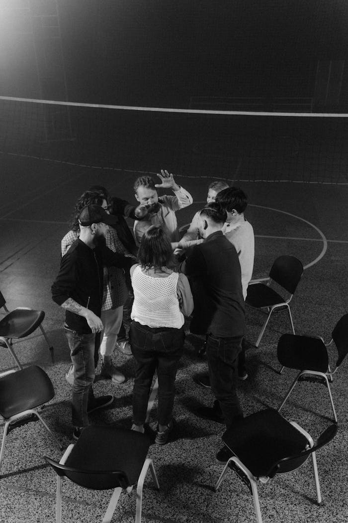 A group of individuals engaged in a discussion circle, captured in dynamic black and white.